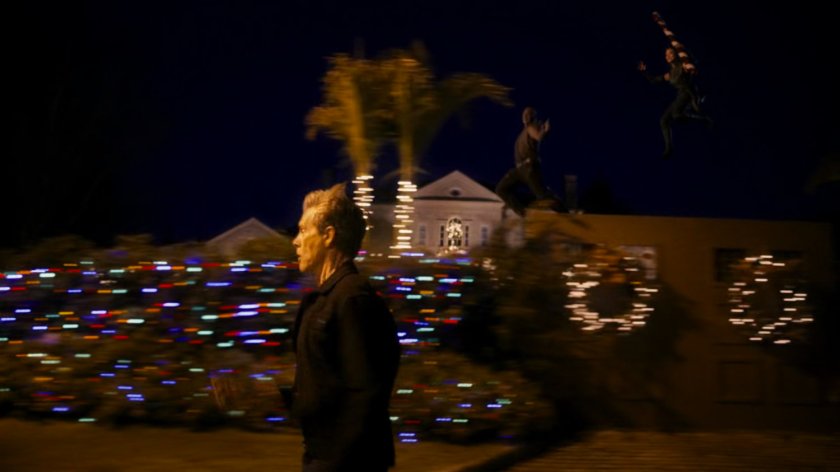 Kevin Bacon running down a street.