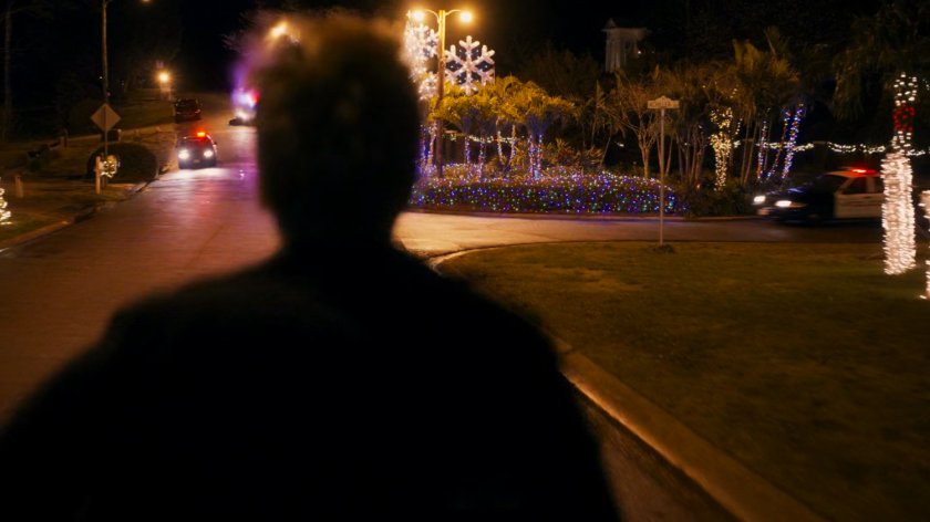 Kevin Bacon runs towards police cars.