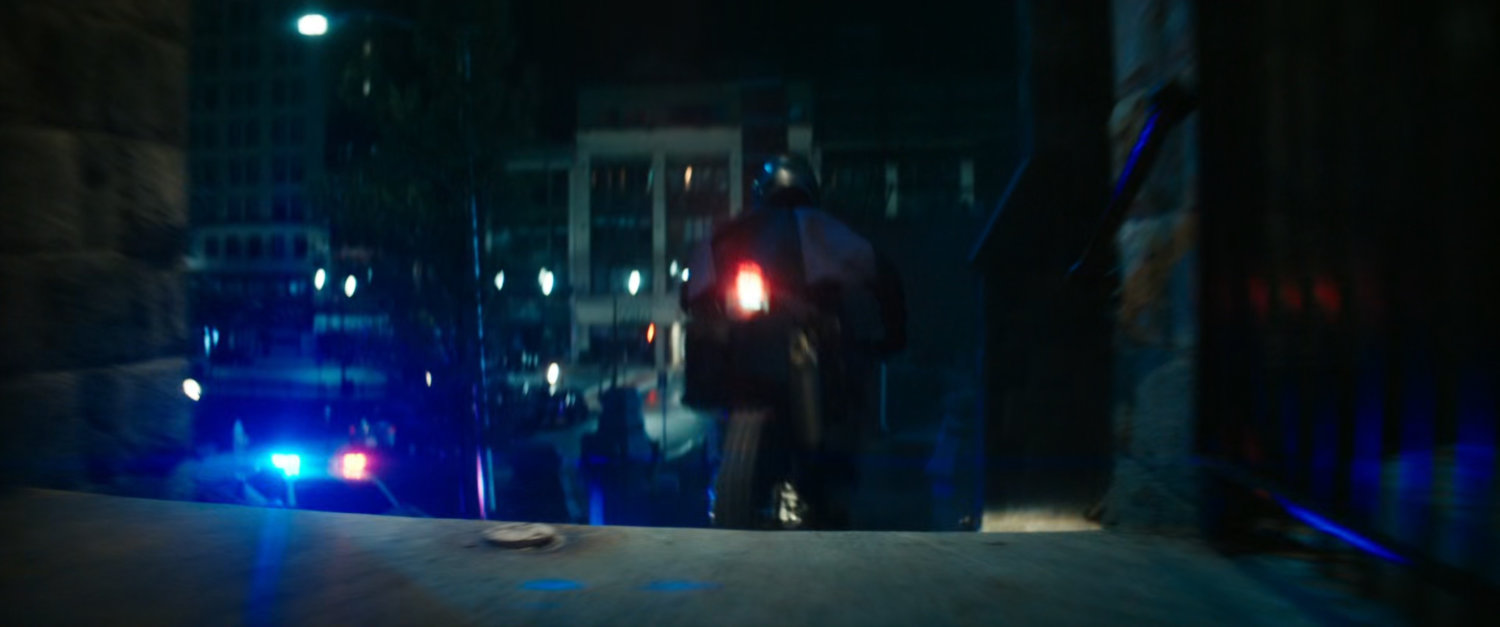 Motorcycle driving on church steps at night.