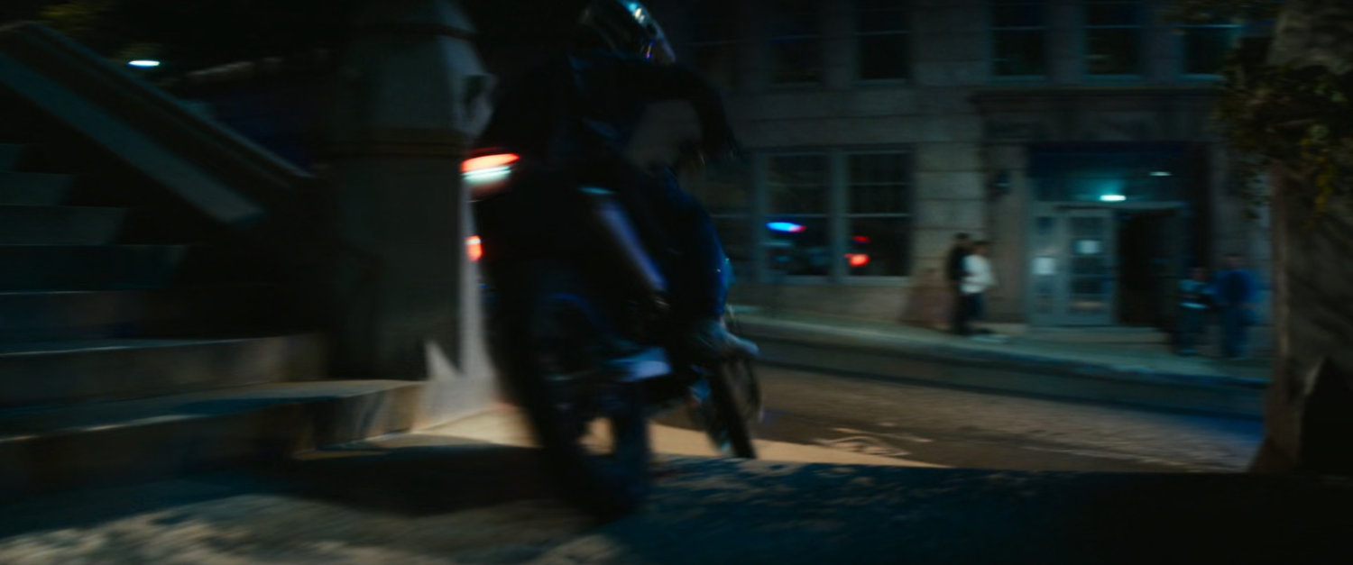 Motorcycle driving on church steps at night.
