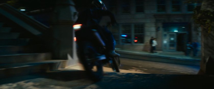 Motorcycle driving on church steps at night.