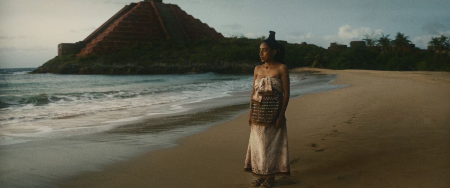 Woman on beach near Mayan pyramid.