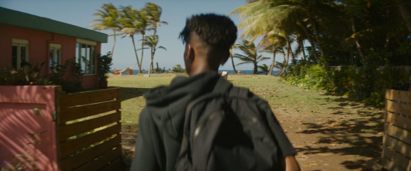 Shuri walks towards a house near the beach.