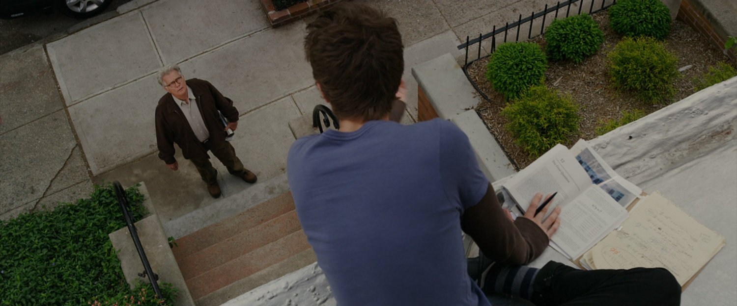 Peter Parker sits on the roof of his house talking to Uncle Ben.