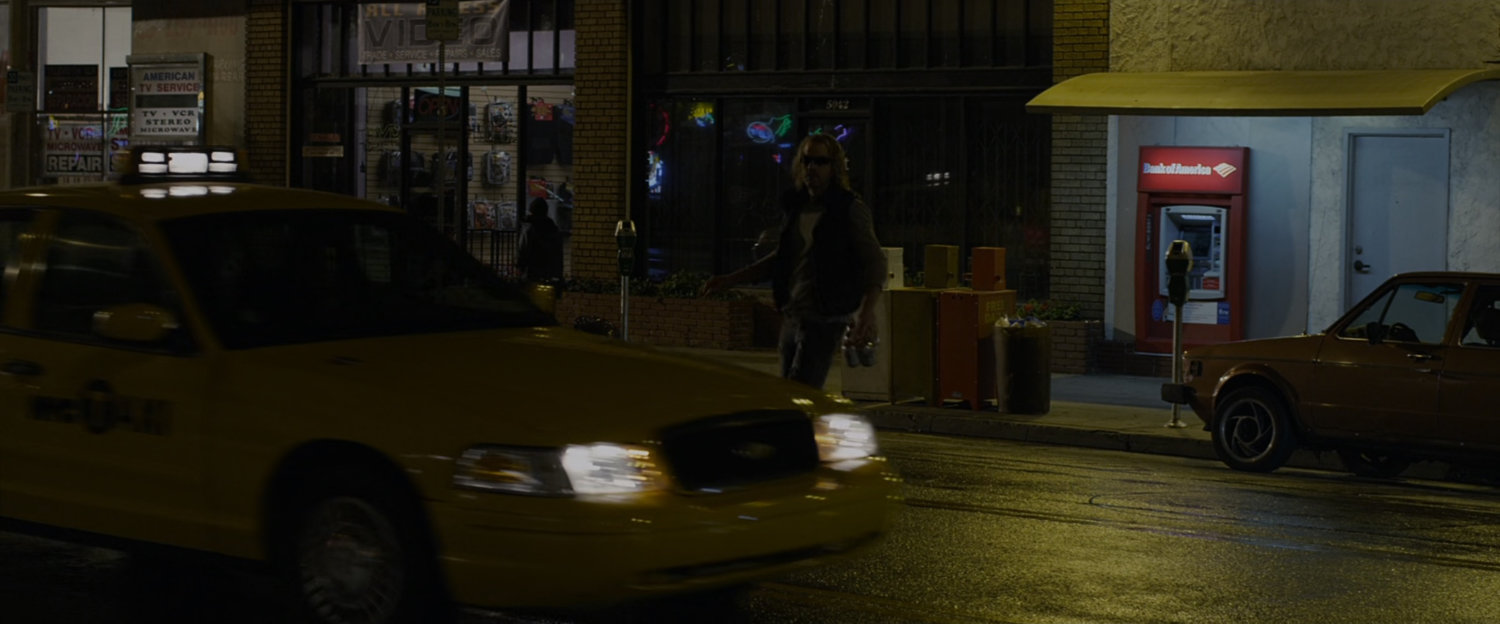 a robber standing in the street at night.