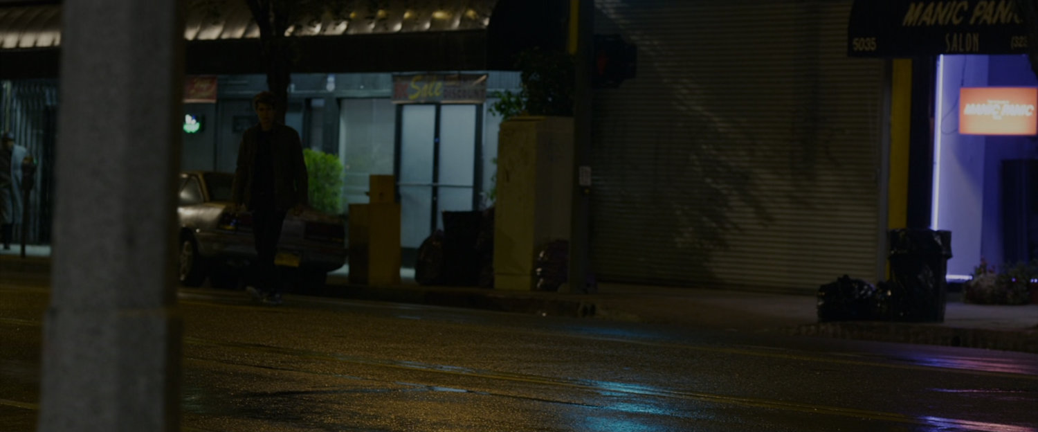 Peter Parker crosses the street at night.