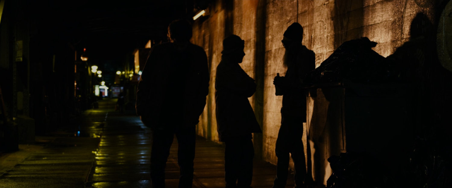 Peter Parker walks along a dark street at night.