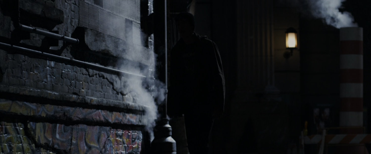 Peter Parker in the shadows of an alleyway.
