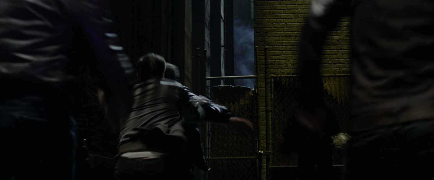 Peter Parker chased by thugs in an alley.