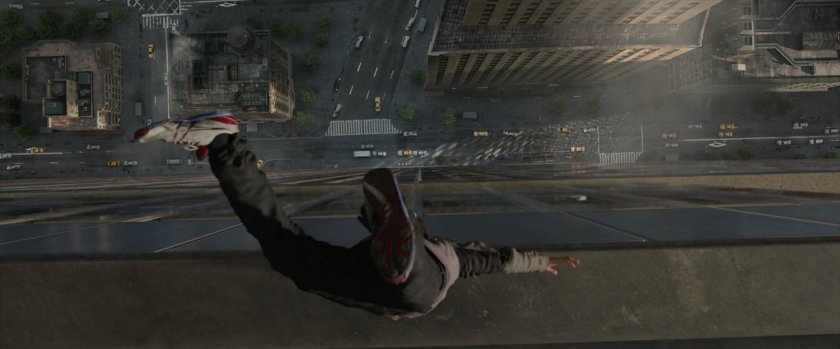 Peter Parker doing a handstand on the roof of a skyscraper, with the street visible below.