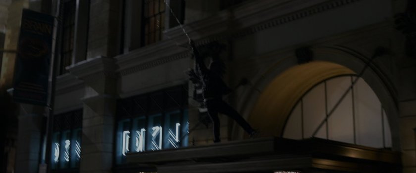 Spider-Man on top of an overhang on a DKNY store.