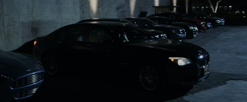 A thief stealing a car in a parking lot.