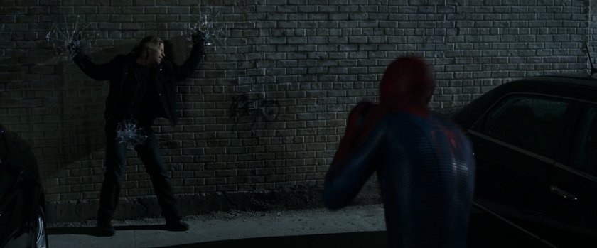 Spider-Man webbing a thief to a wall.