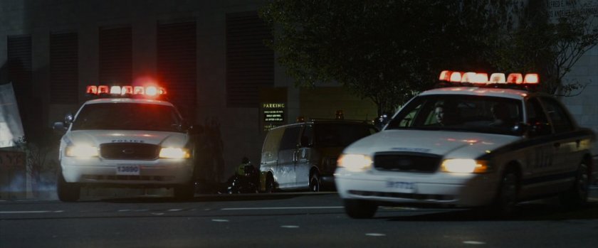 Police cars race by on the street.