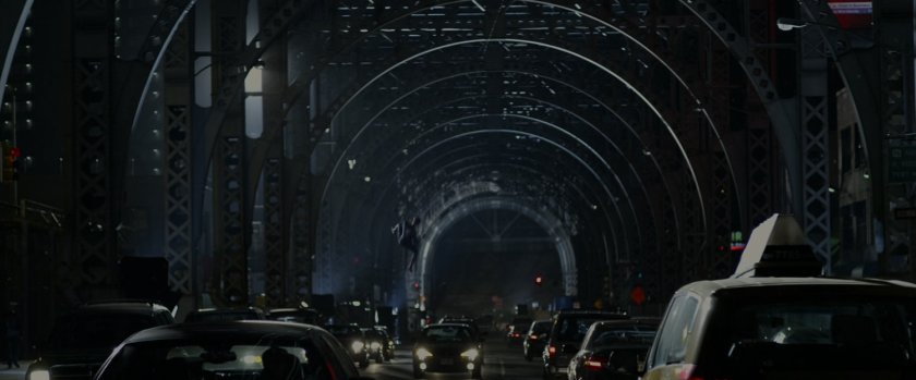 Spider-Man swinging under a bridge.