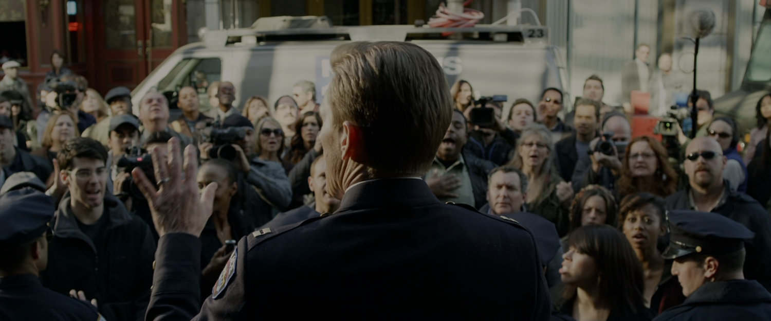 Captain Stacy addresses a crowd outside police headquarters.