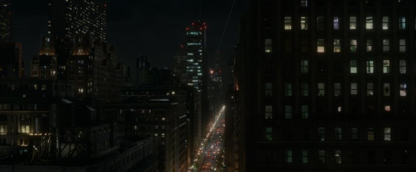 Aerial view of New York City, looking up busy street at night.