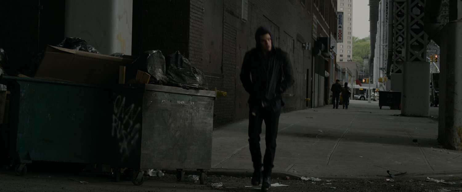 Peter Parker walks down sidewalk.