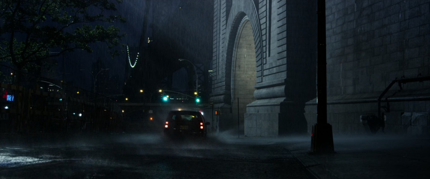 A rainy street at the footing of a bridge in New York City.