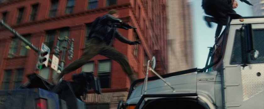 Robbers jumping from tow truck to armored car.