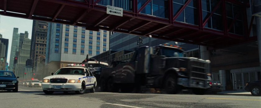 Tow truck hits police car under pedestrian bridge.