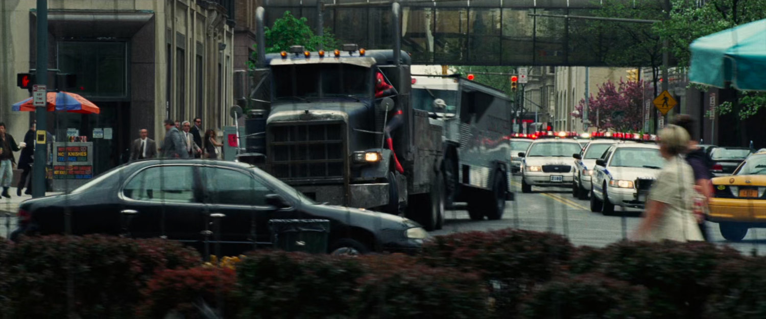 Tow truck with armored car chased by police cars.