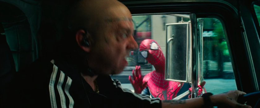 Alexei Sytsevich in the cab of a tow truck with Spider-Man outside.