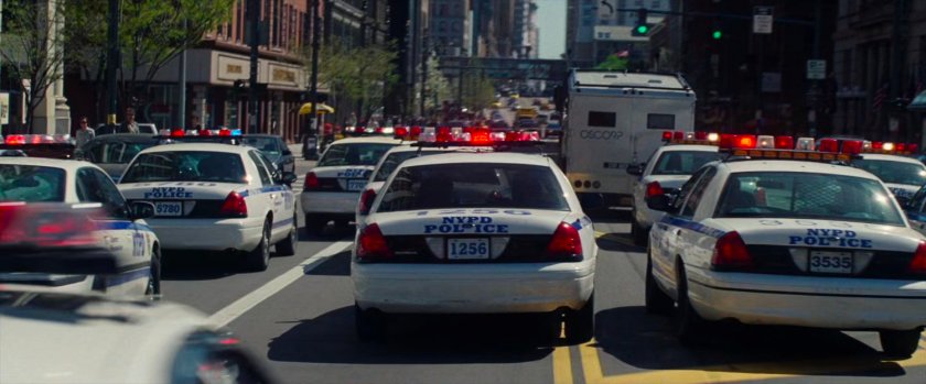 Police cars chase stolen Oscorp armored car.