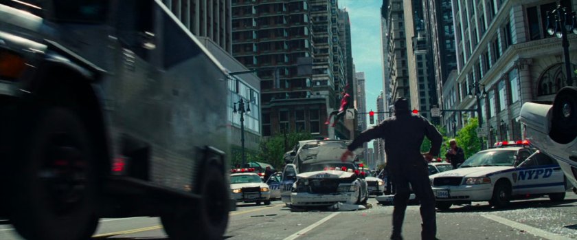 Spider-Man swings towards robber in street.