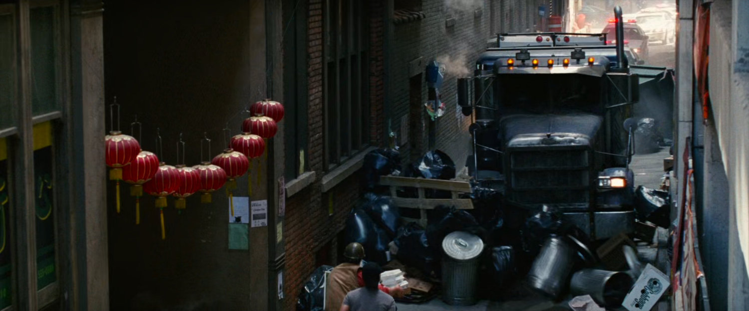Tow truck driving through alley, hitting dumpsters and trash bags.