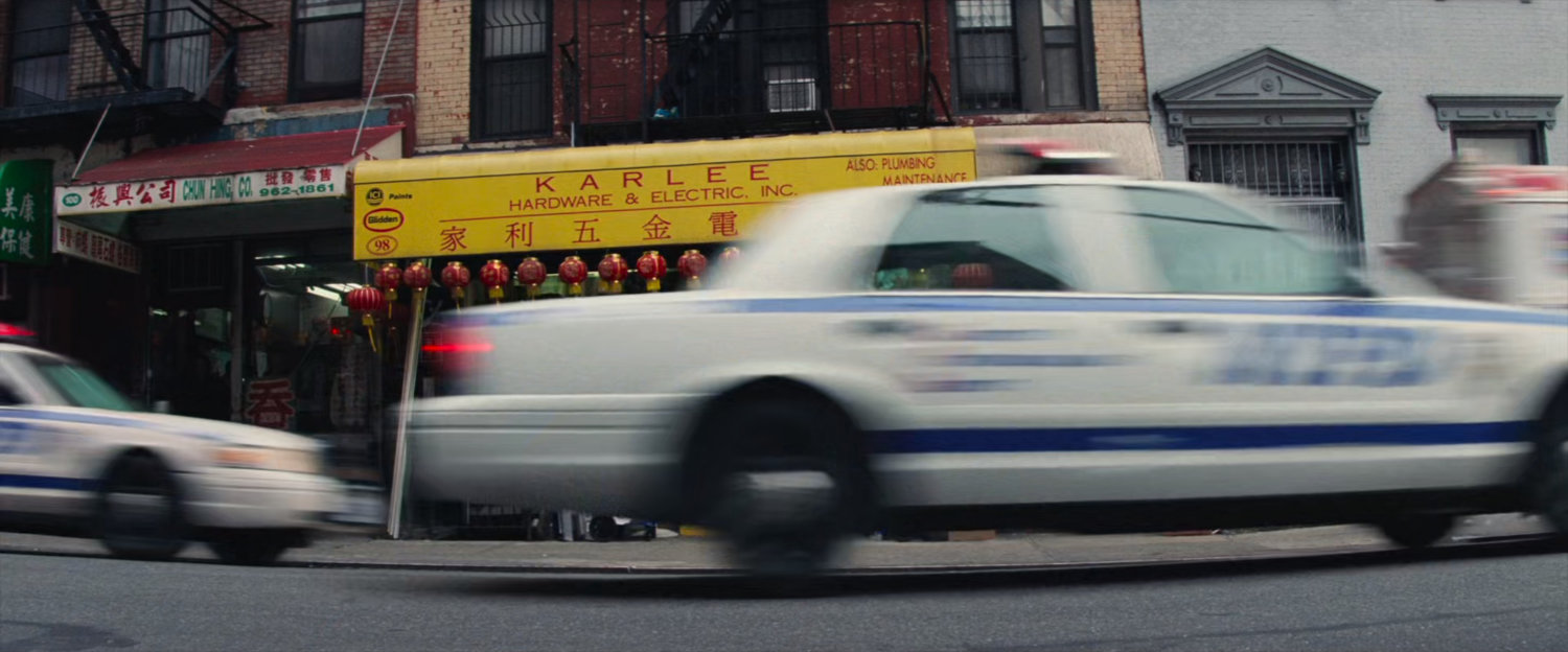 Police cars race through a Chinatown street.