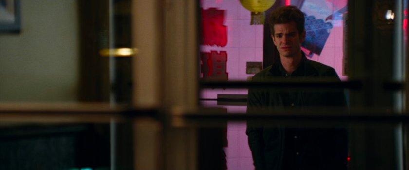 Peter Parker looks through a window into a Chinese restaurant.