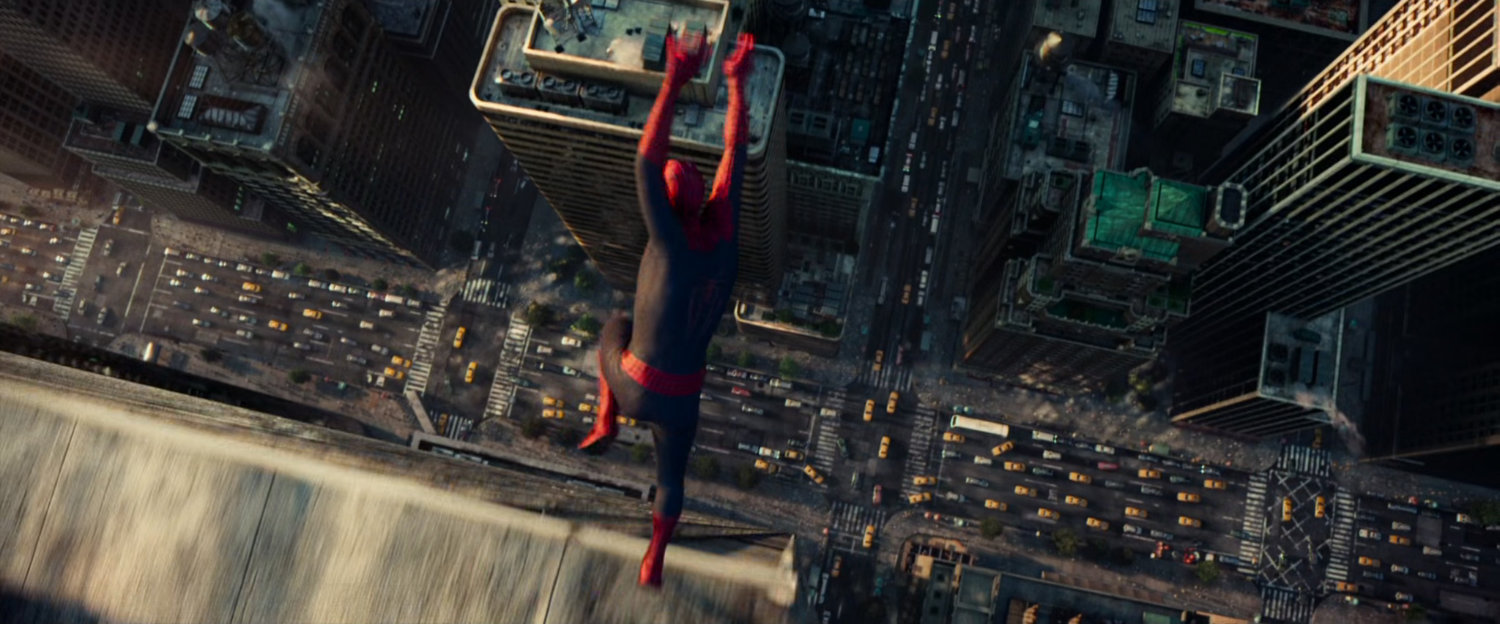 Spider-Man leaps off a building above a busy street.