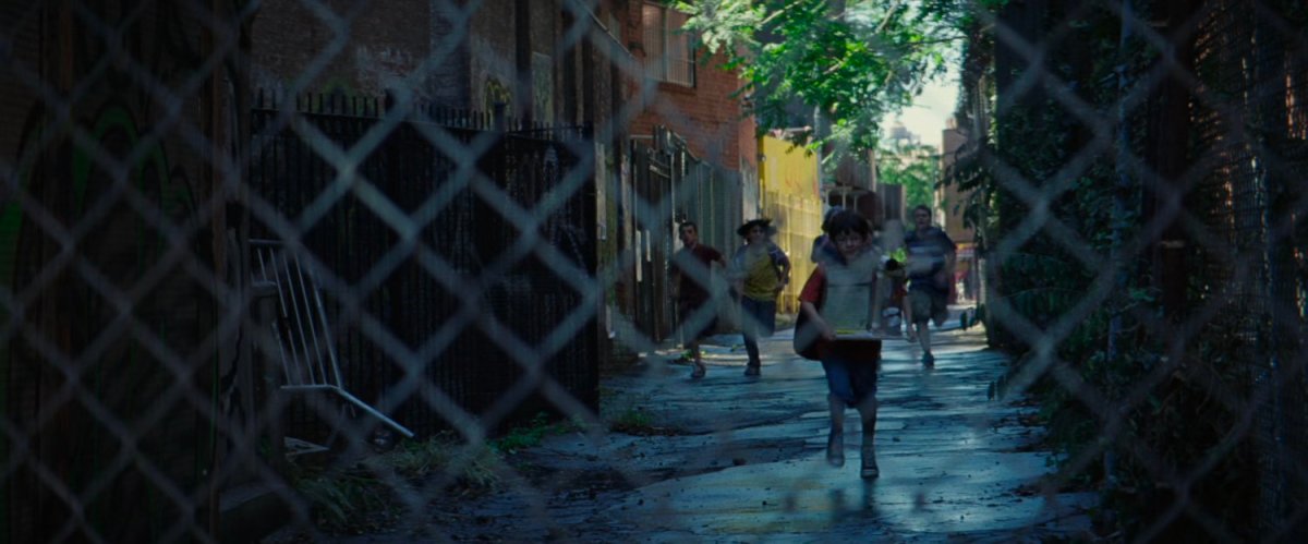 Young boy chased down an alley by some older boys.