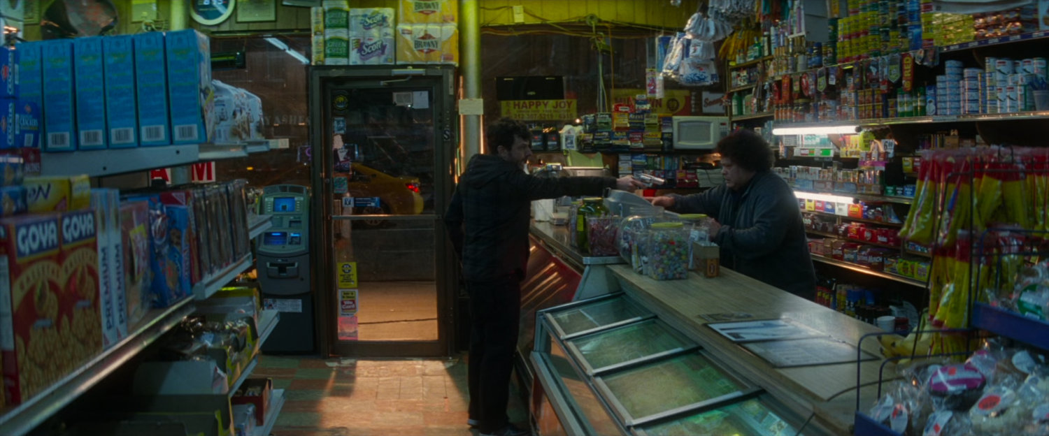 Robber pointing gun at Bodega clerk.