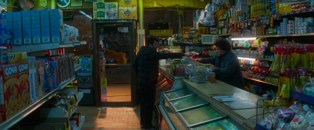 Robber pointing gun at Bodega clerk.