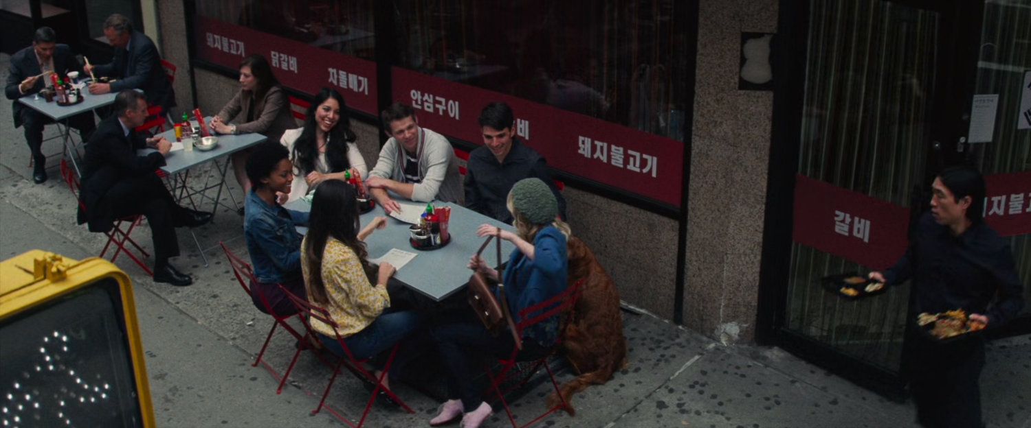 Gwen an her friends eating at a sidewalk restaurant.