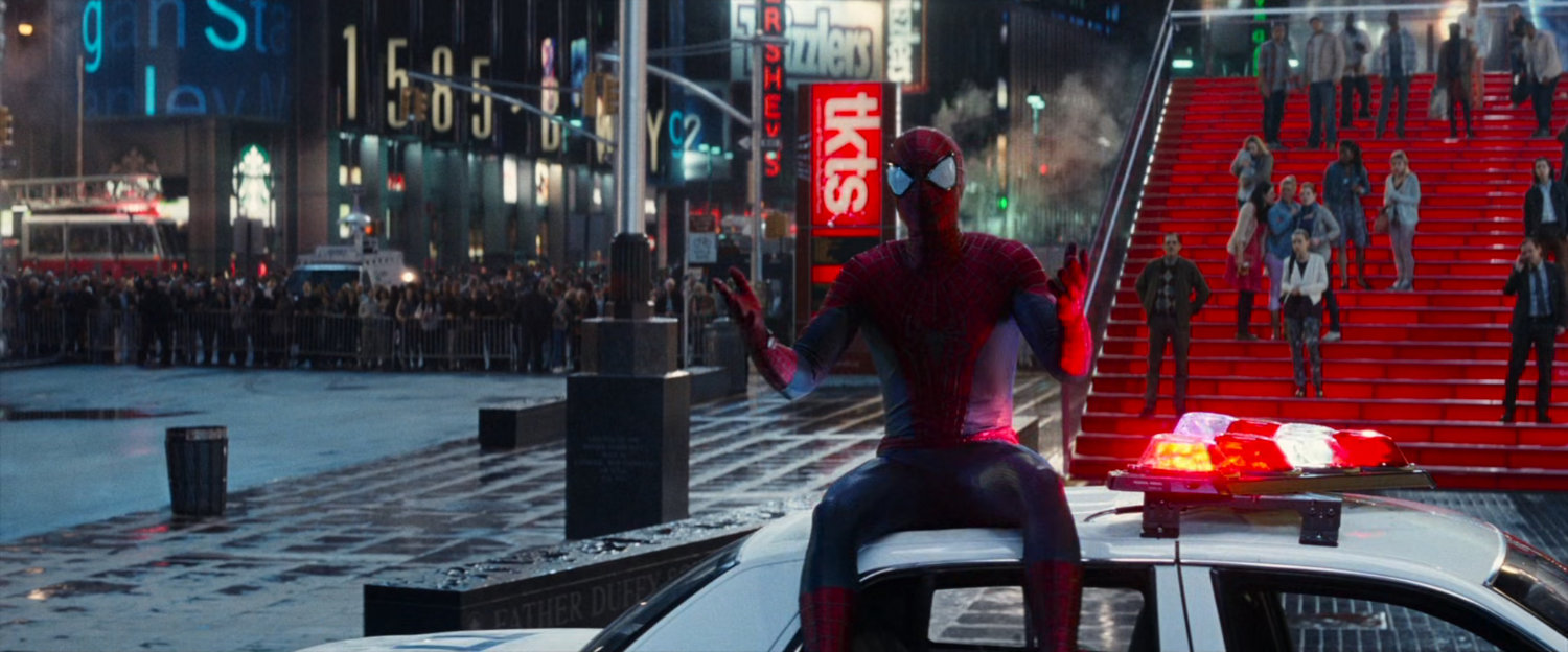 Spider-Man sitting on a police car in Times Square.