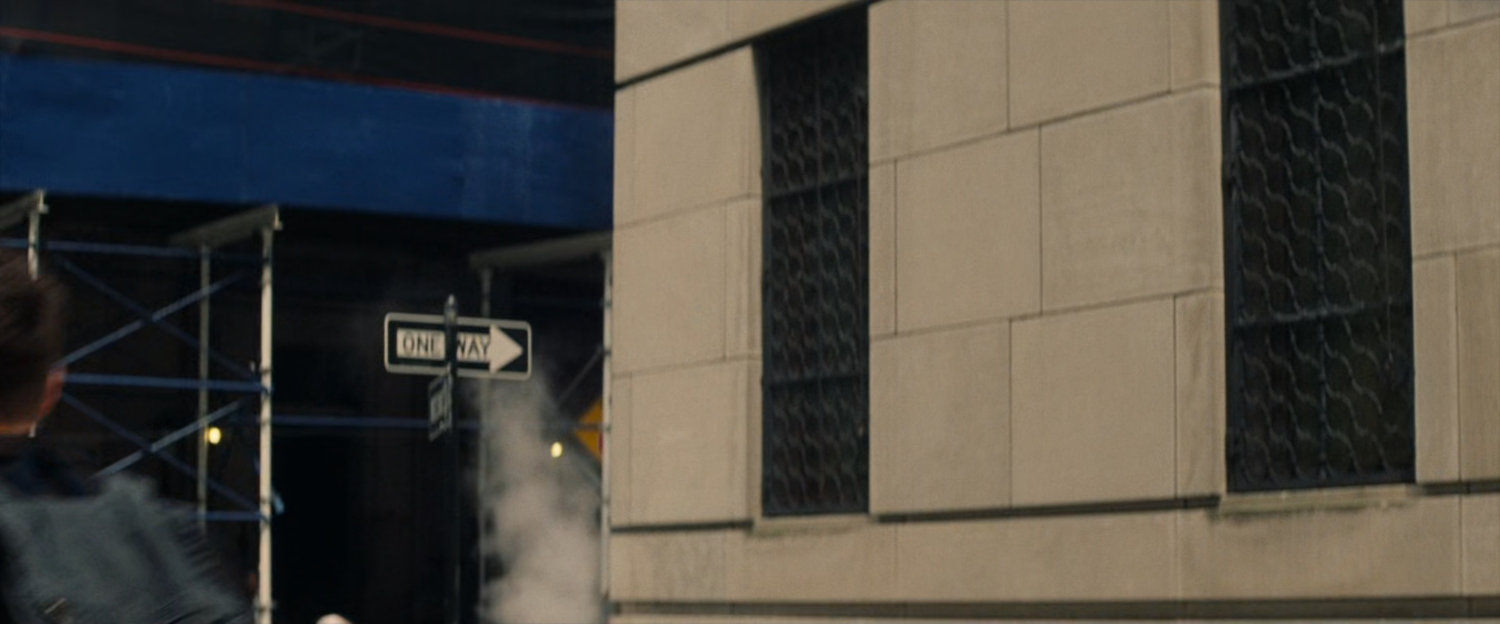 Corner of building and One Way sign.