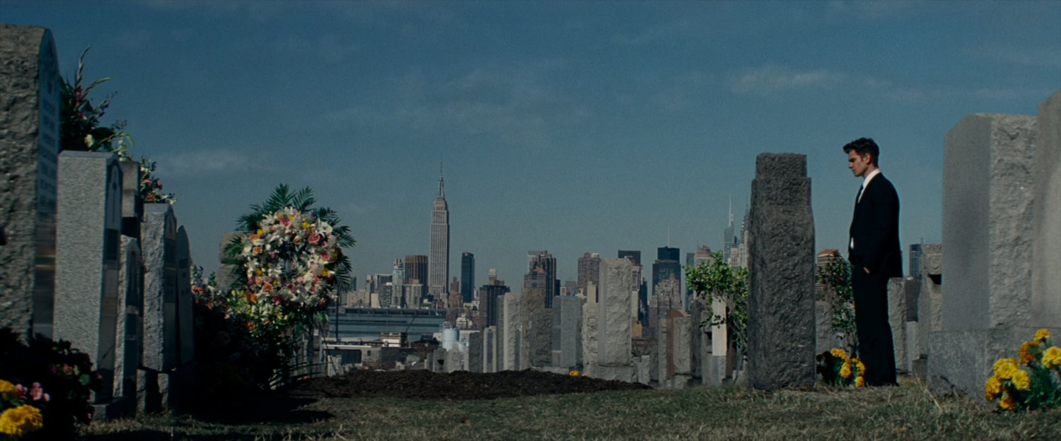 Peter Parker at cemetery with New York in background.