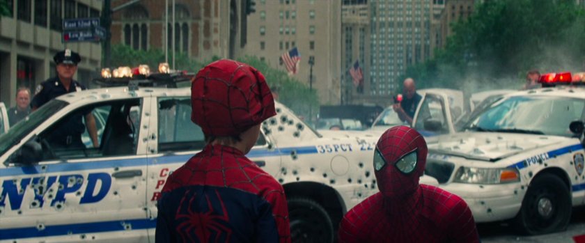 Spider-Man talks to a small bot in a Spidey costume.