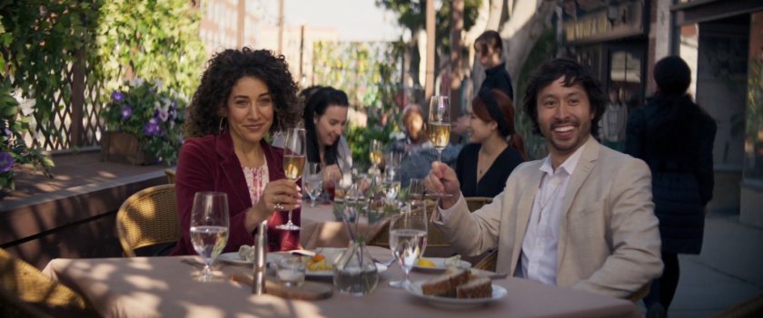 A couple toast Scott and Jimmy, sitting at an outdoor cafe.