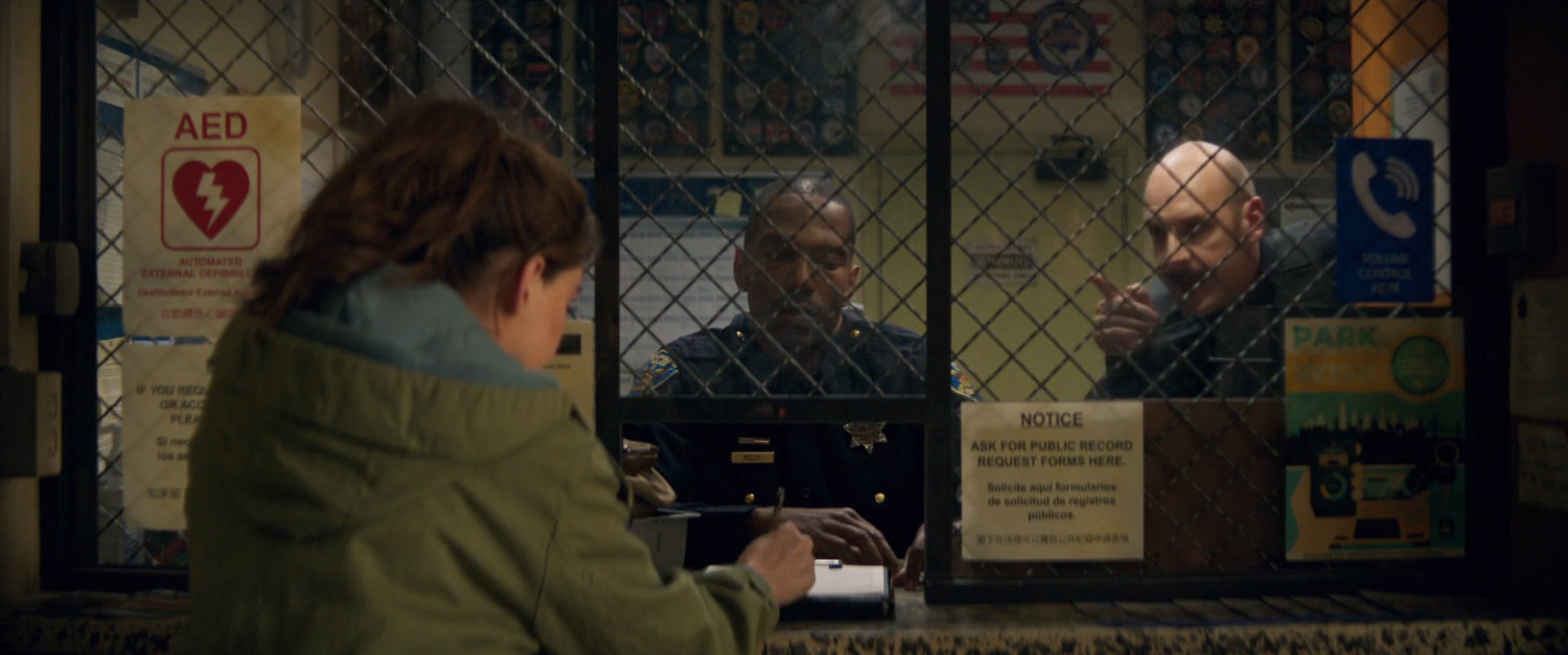 Cassie Lang and two officers inside a police station.