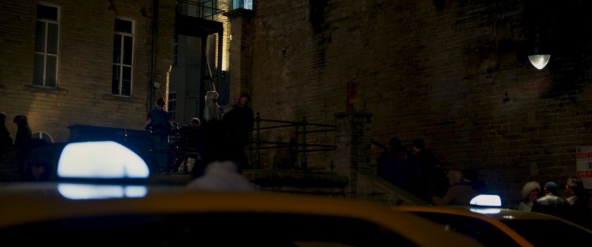 Agent Ross on Moscow stairs outside brick building.