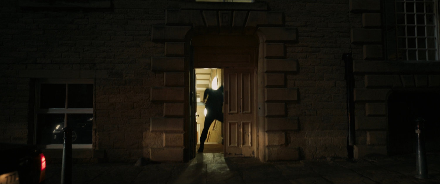 Exterior of a Moscow building with silhouetted figure in backlit doorway.