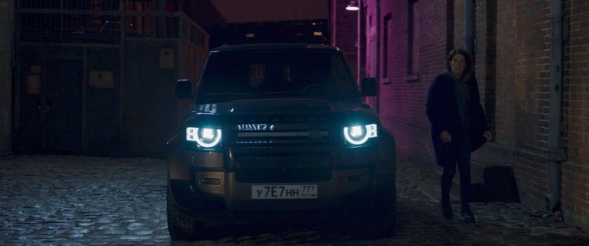 Maria Hill exiting SUV on cobblestone road.