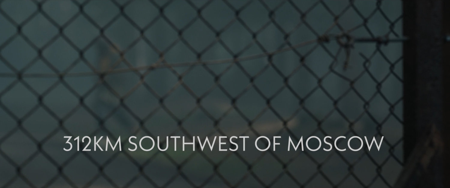 Chain link fence. Text: 312 KM Southwest of Moscow.