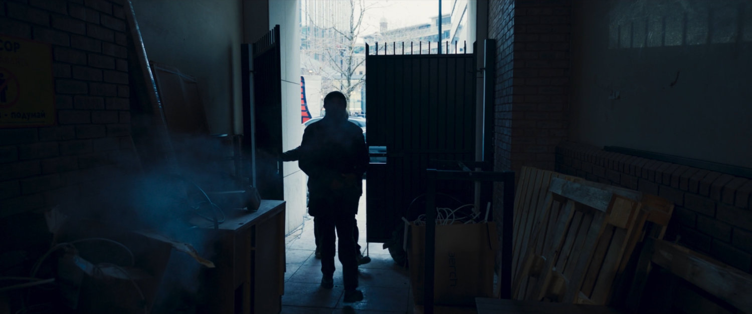 Nick Fury and Talos enter a gated alley.