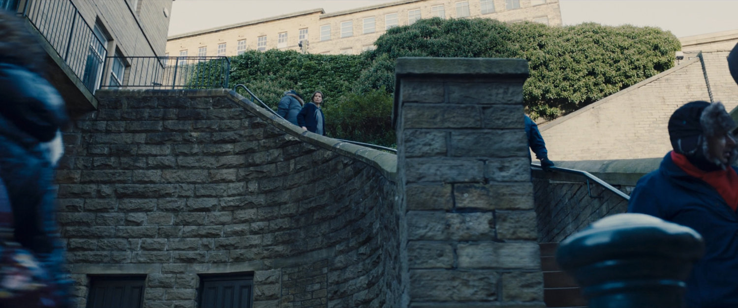 Maria Hill descends a stone staircase.