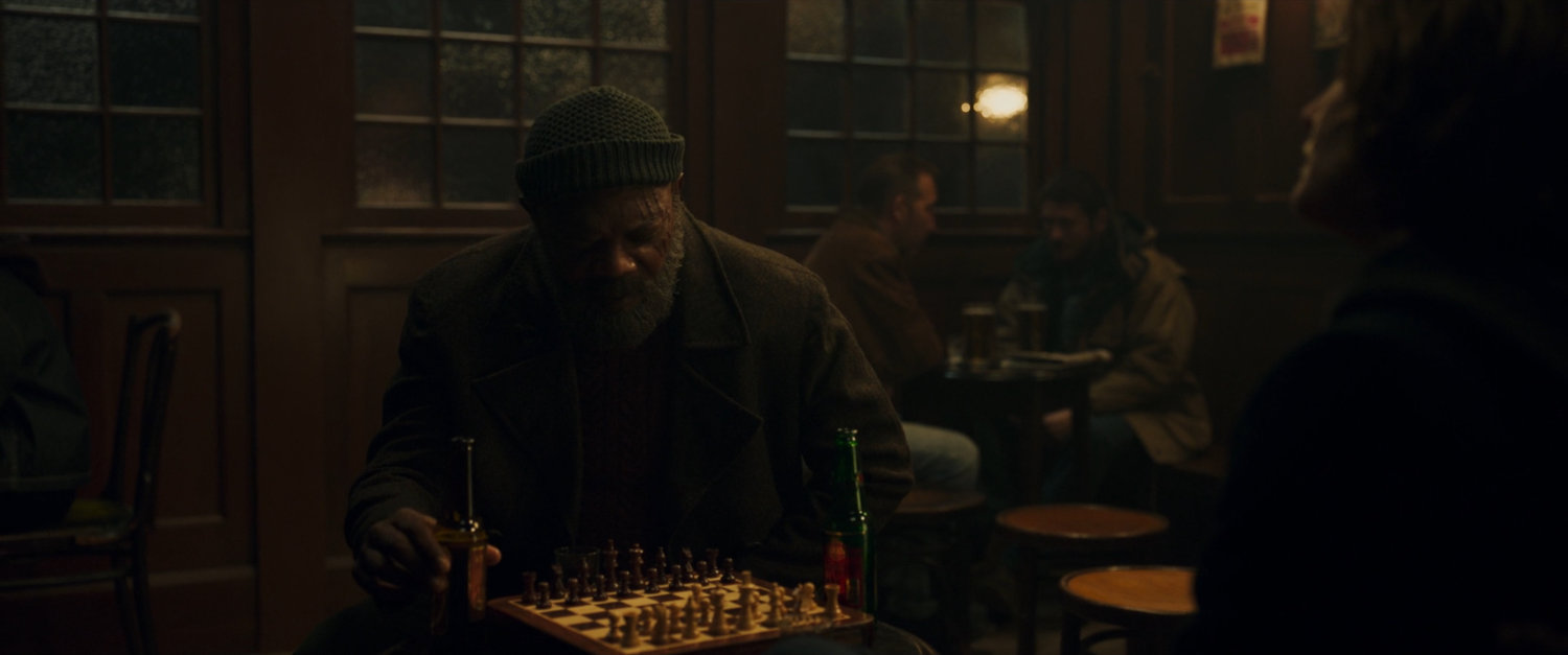 Nick Fury in Pub sitting over a chess board.
